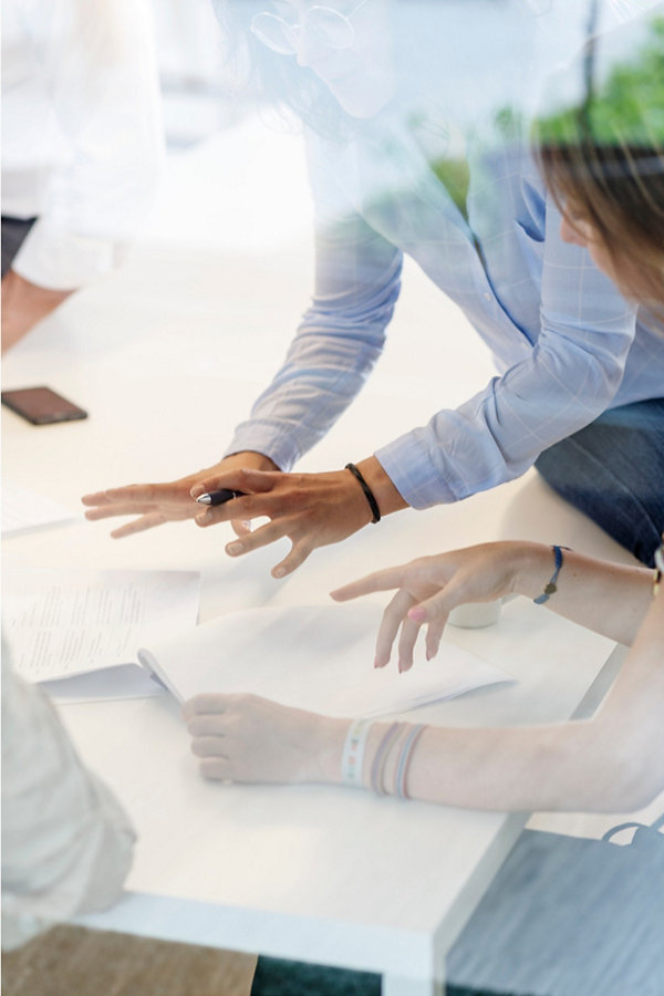 Discussion Hands emphasizing Idea Paper on the Table