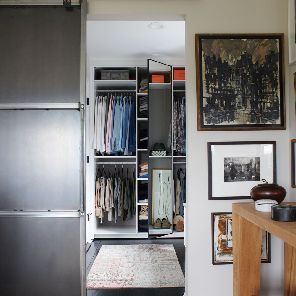 Wall space displaying a collection of modern art with a closet entry in the center.