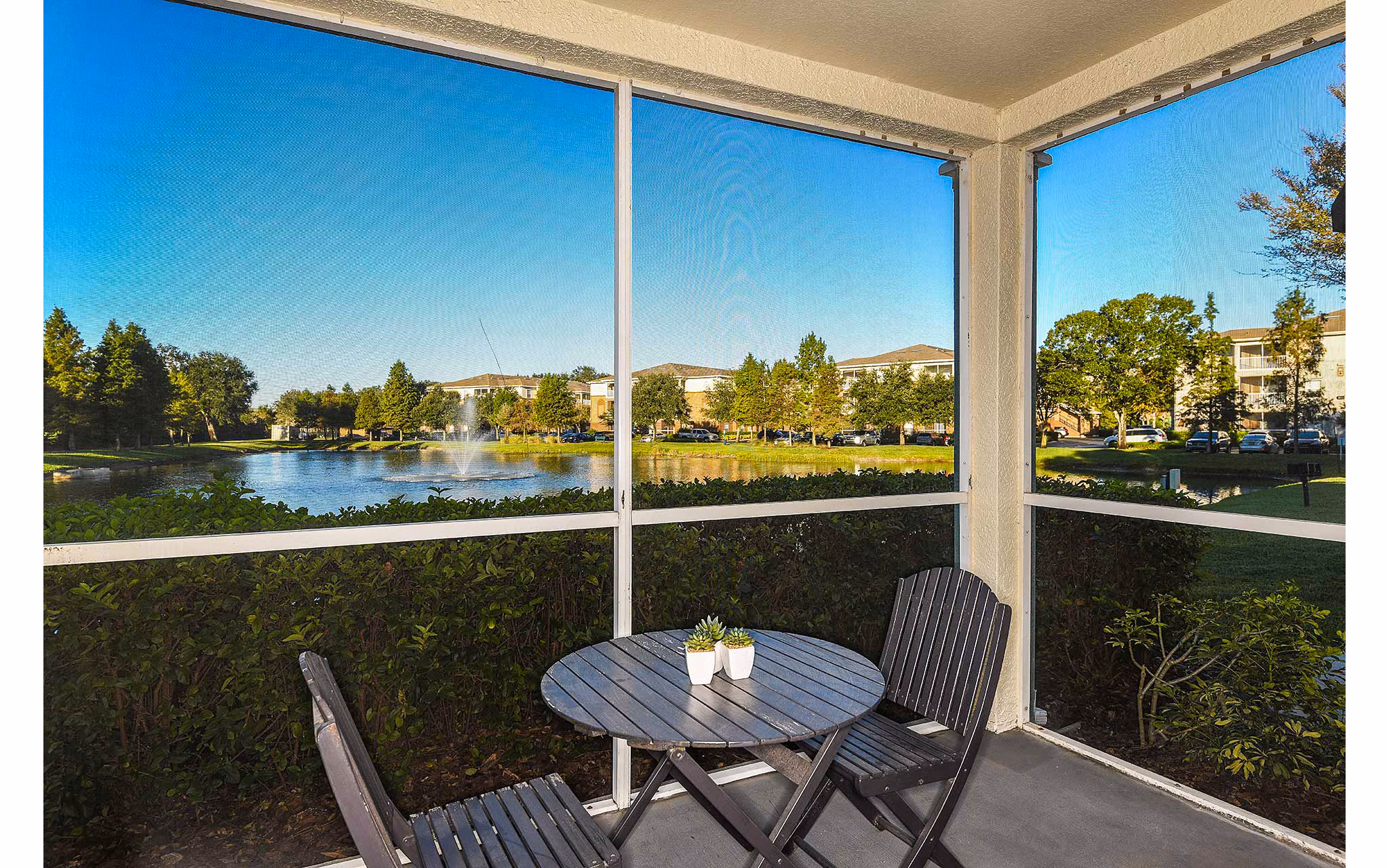 Private patio at Villas at Gateway Apartments featuring comfortable seating and overlooking lush gardens