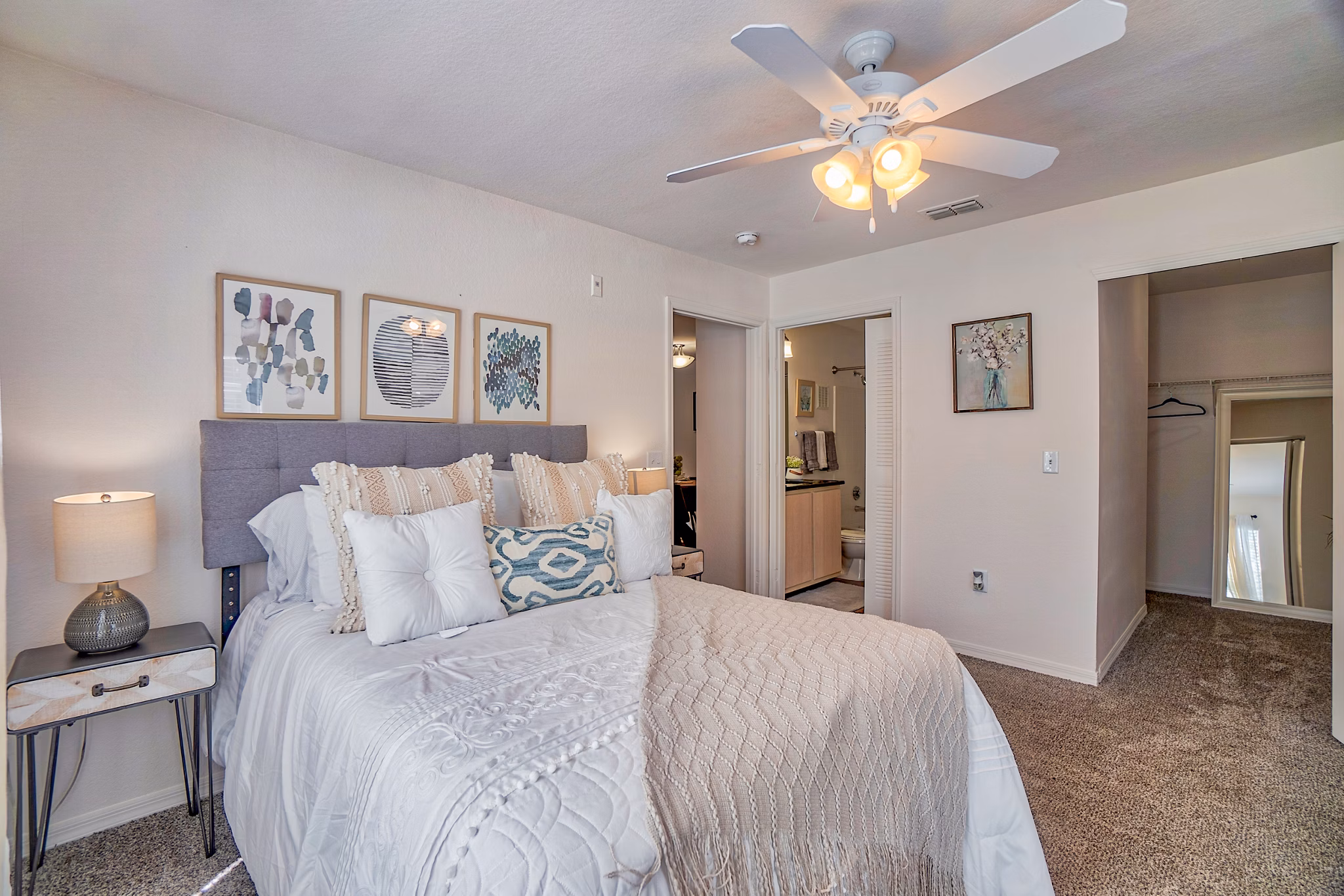 Cozy bedroom with plush bedding in Elmhurst Village Apartments featuring luxury living amenities