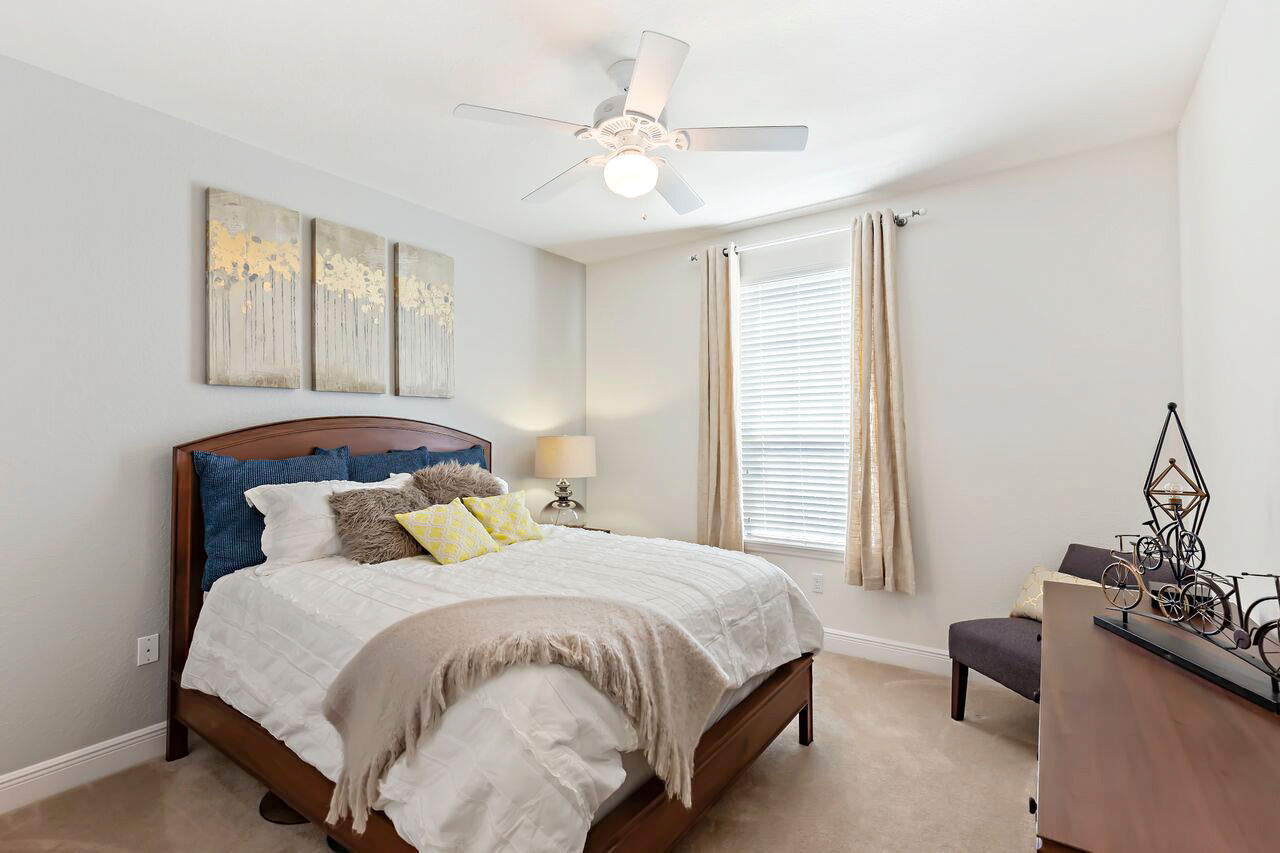 Cozy bedroom with modern furnishings at Trinity Club Apartments, featuring luxury living in a serene setting