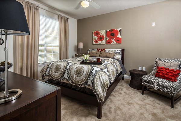 Cozy bedroom with queen-size bed and natural light at Trinity Club Apartments