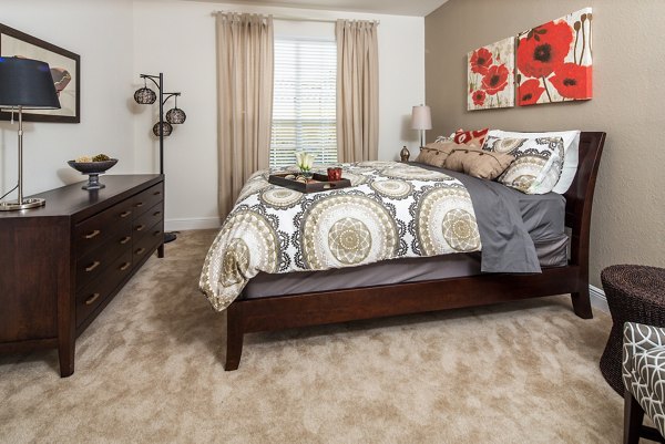 Bedroom with king-size bed, modern decor, and natural light at Trinity Club Apartments