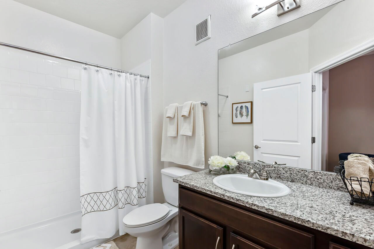 Elegant bathroom with modern fixtures and marble countertop at Trinity Club Apartments