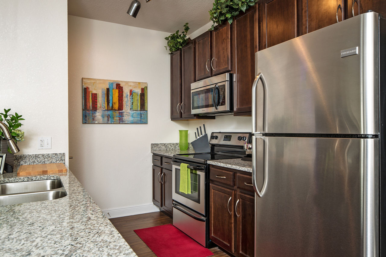Modern kitchen with stainless steel appliances at Trinity Club Apartments