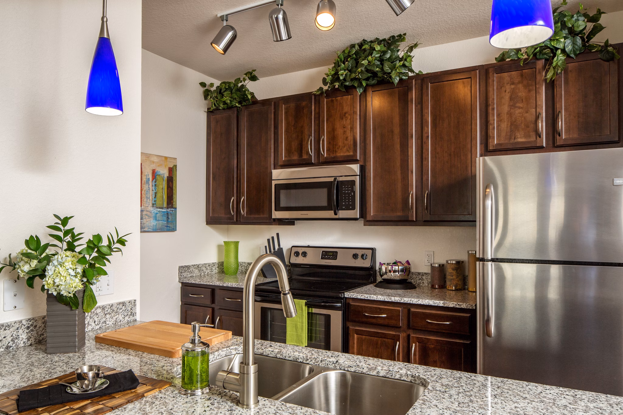 Modern kitchen with stainless steel appliances and granite countertops at Trinity Club Apartments