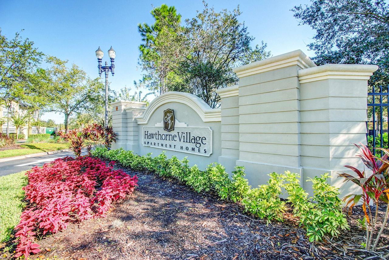 Hawthorne Village Apartments: Entrance signage highlighting luxury living in a serene community