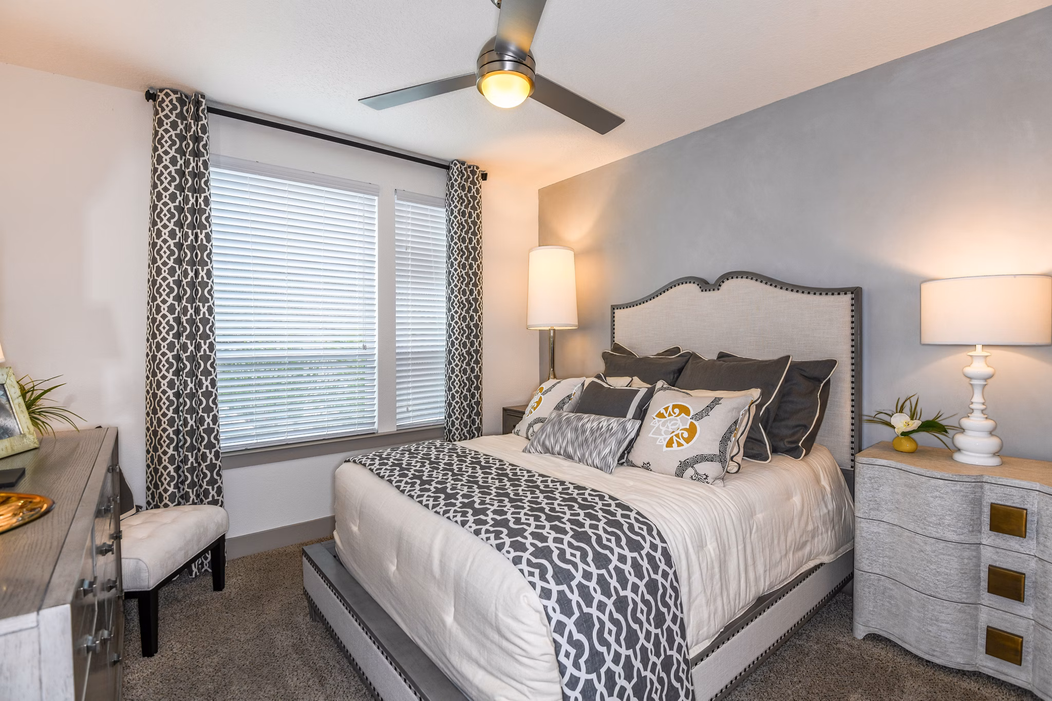 Modern bedroom with stylish decor and large windows at The Gallery at Mills Park Apartments