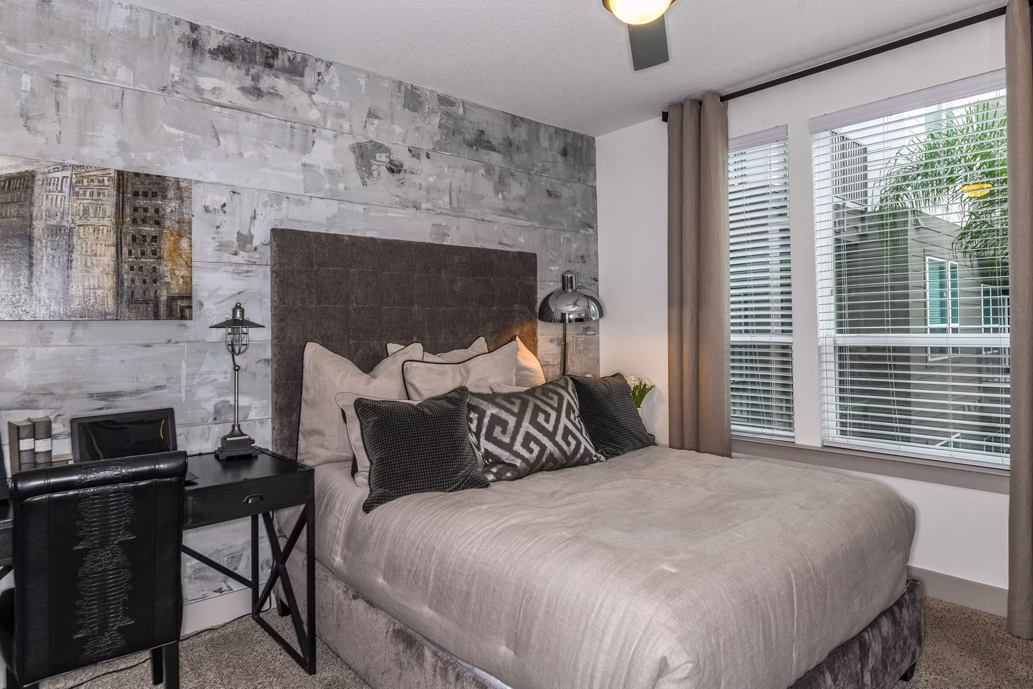Cozy bedroom with modern decor at The Gallery at Mills Park Apartments, Orlando, featuring king-sized bed and ample natural light