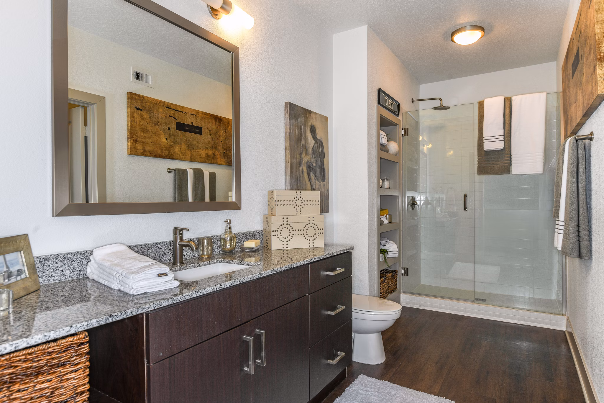 Modern bathroom featuring dual sinks and granite countertops at The Gallery at Mills Park Apartments