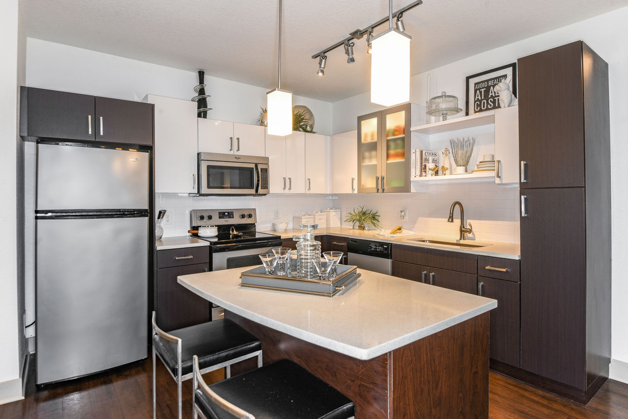 Modern kitchen with stainless steel appliances in The Gallery at Mills Park Apartments