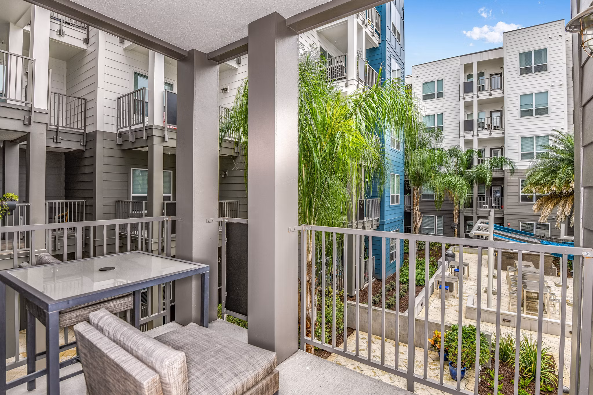 Modern patio at The Gallery at Mills Park Apartments featuring stylish seating and lush landscaping