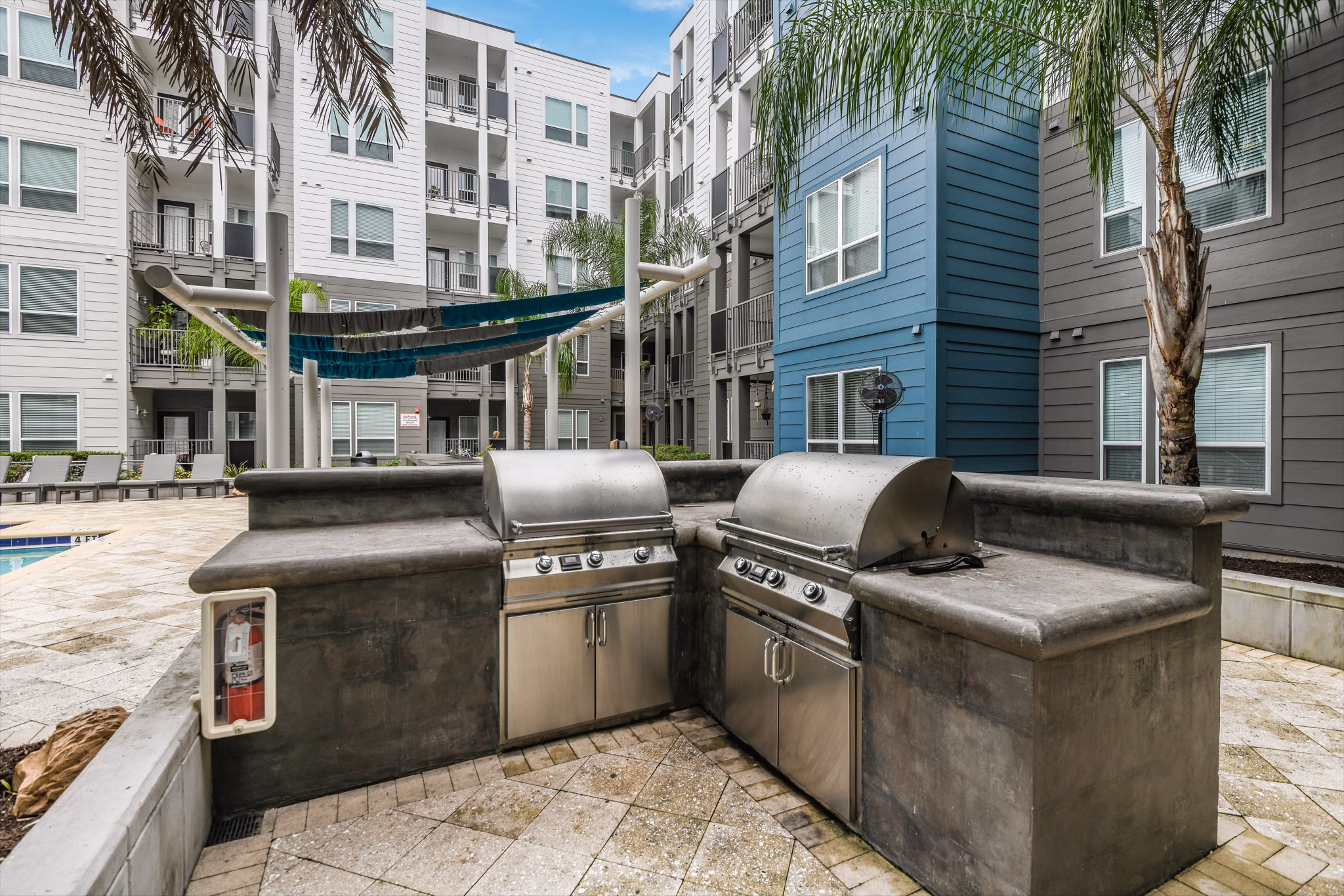 Outdoor grill area with modern seating at The Gallery at Mills Park Apartments, ideal for social gatherings and dining al fresco