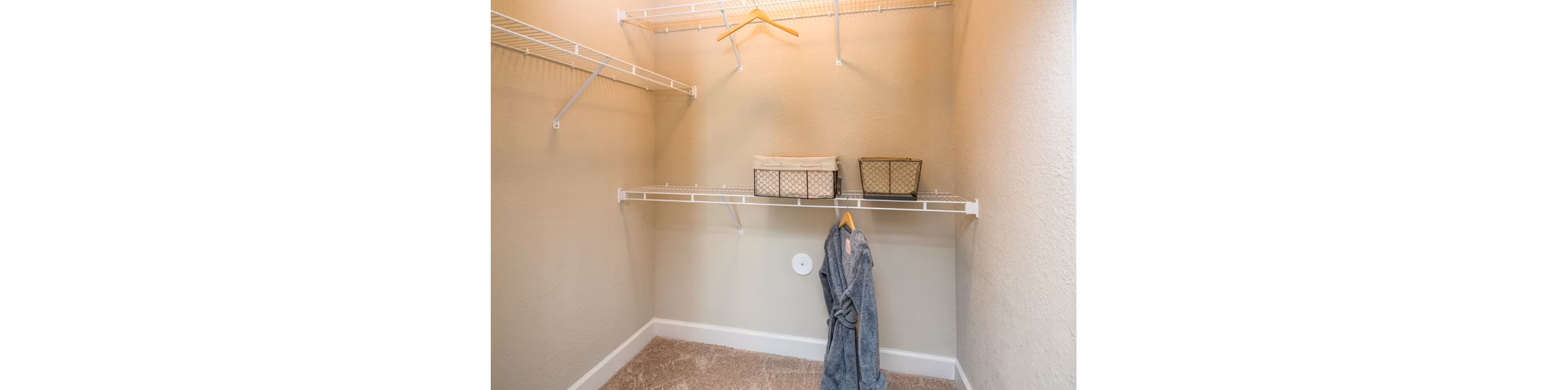 Spacious walk-in closet with built-in shelving in Trinity Exchange Luxury Apartments