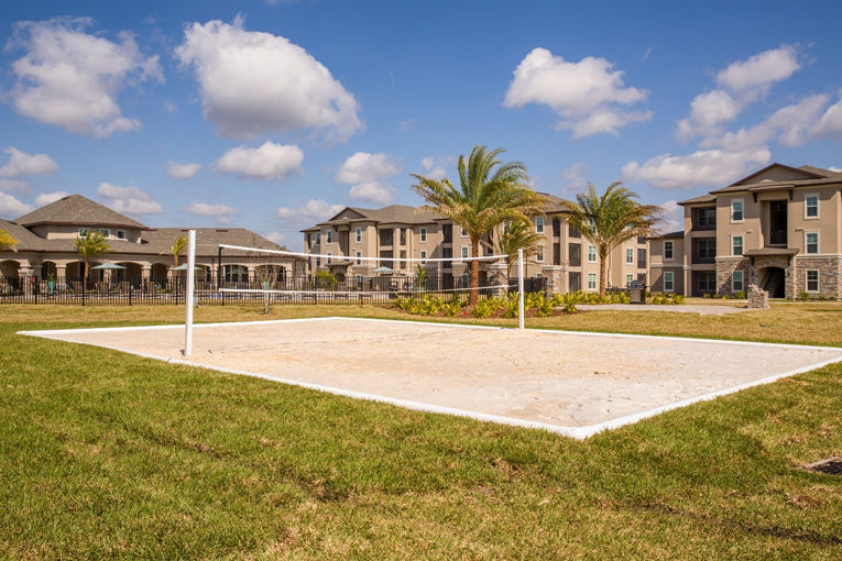 Outdoor volleyball court with lush landscaping at Trinity Exchange Luxury Apartments