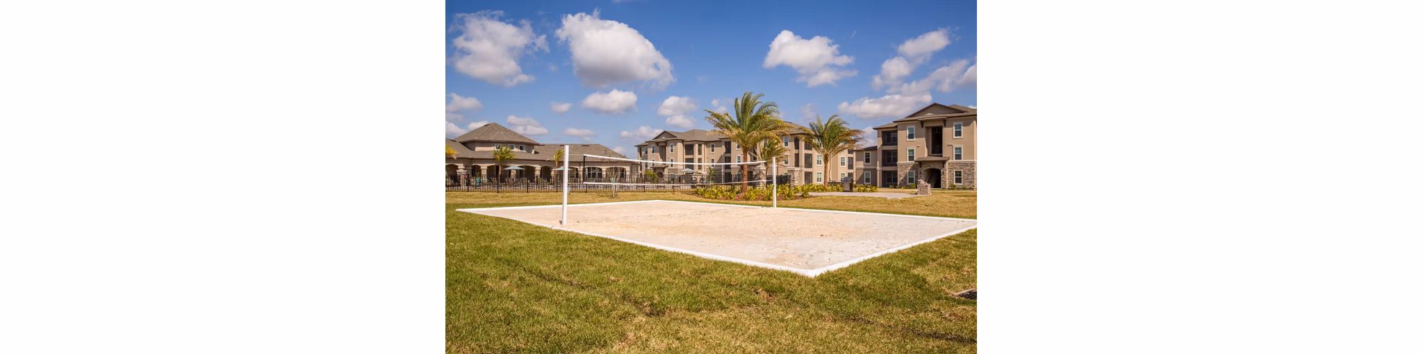 Outdoor volleyball court with lush landscaping at Trinity Exchange Luxury Apartments