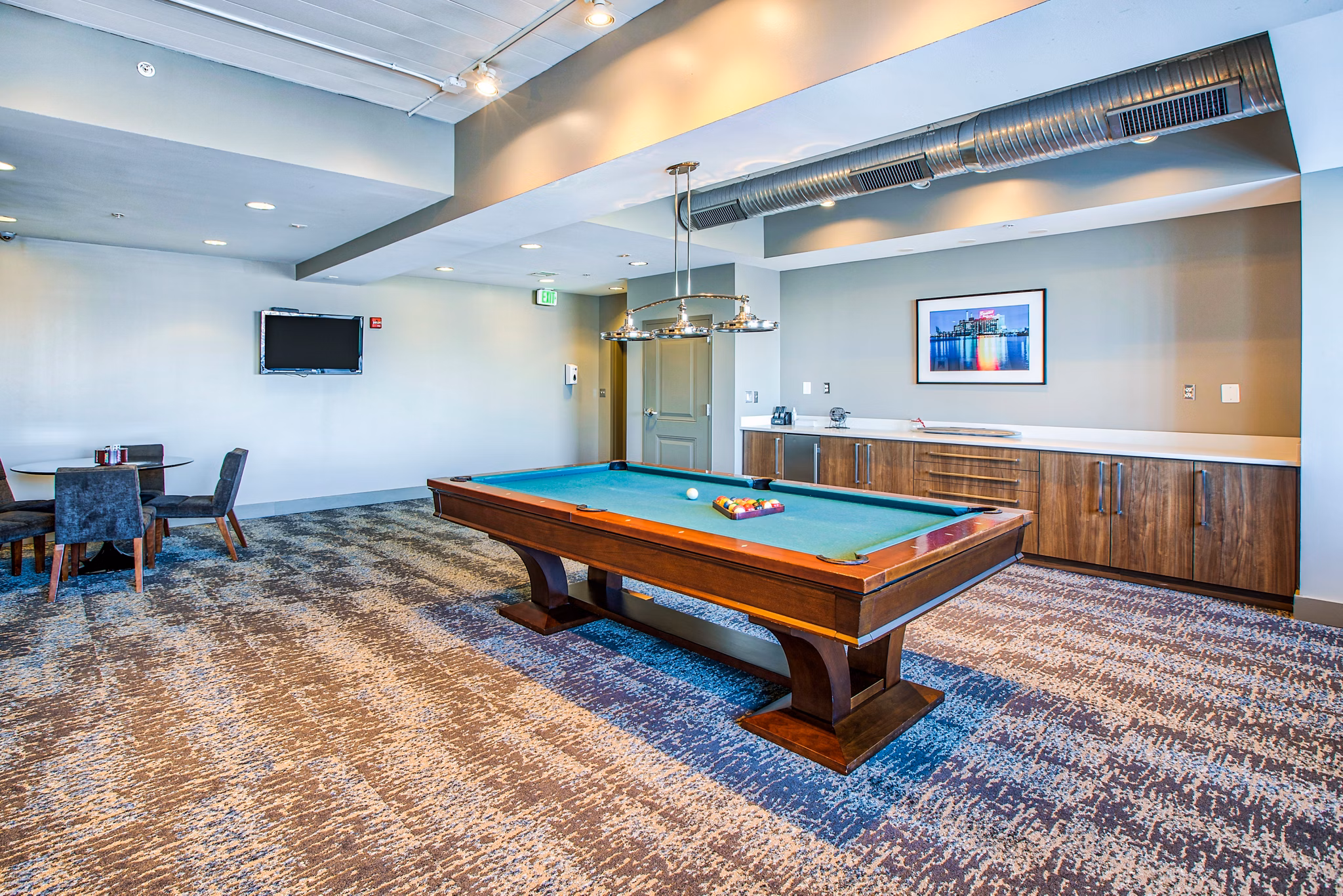 Game room with pool table and lounge area at McHenry Row Apartments, a luxury community offering premier amenities and social spaces