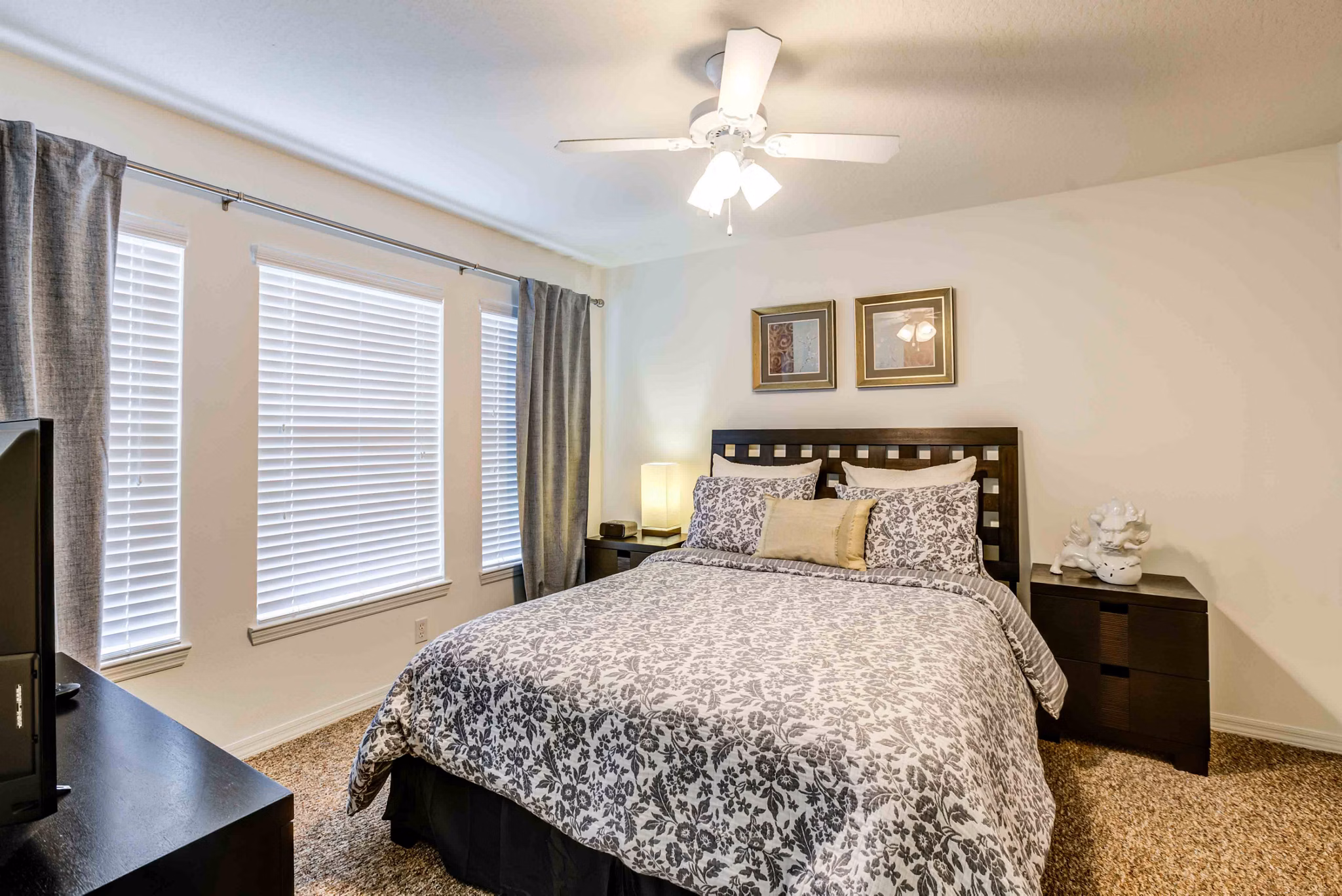 Cozy bedroom with modern decor at Parks at Hunter's Creek Apartments, featuring plush bedding and natural light