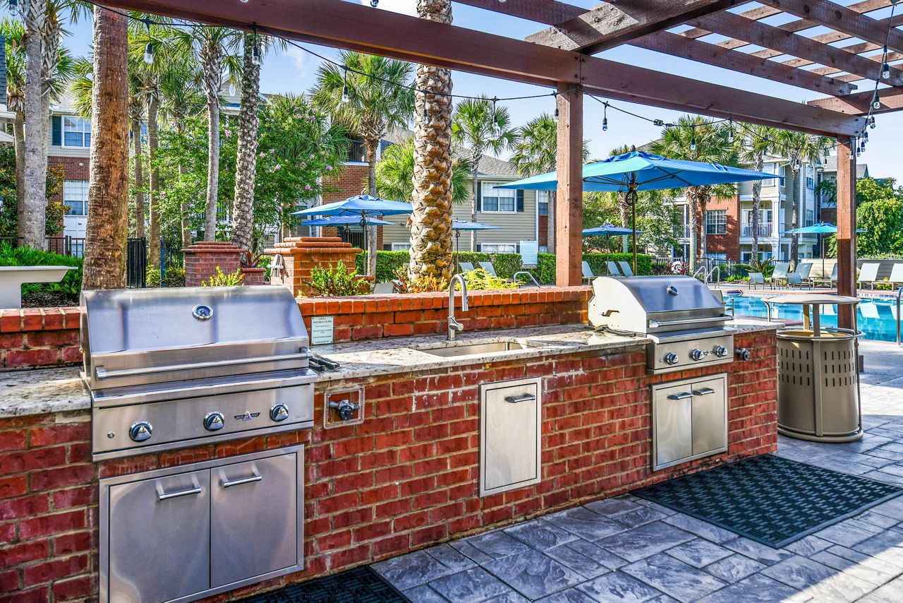Grill area with modern patio seating at 54 Magnolia Apartments, ideal for outdoor gatherings and relaxation