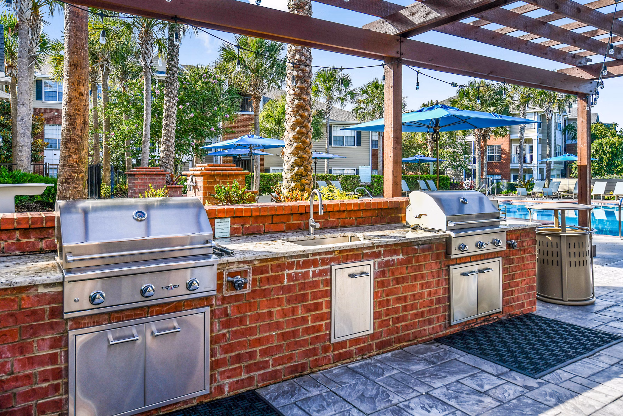 Grill area with modern patio seating at 54 Magnolia Apartments, ideal for outdoor gatherings and relaxation