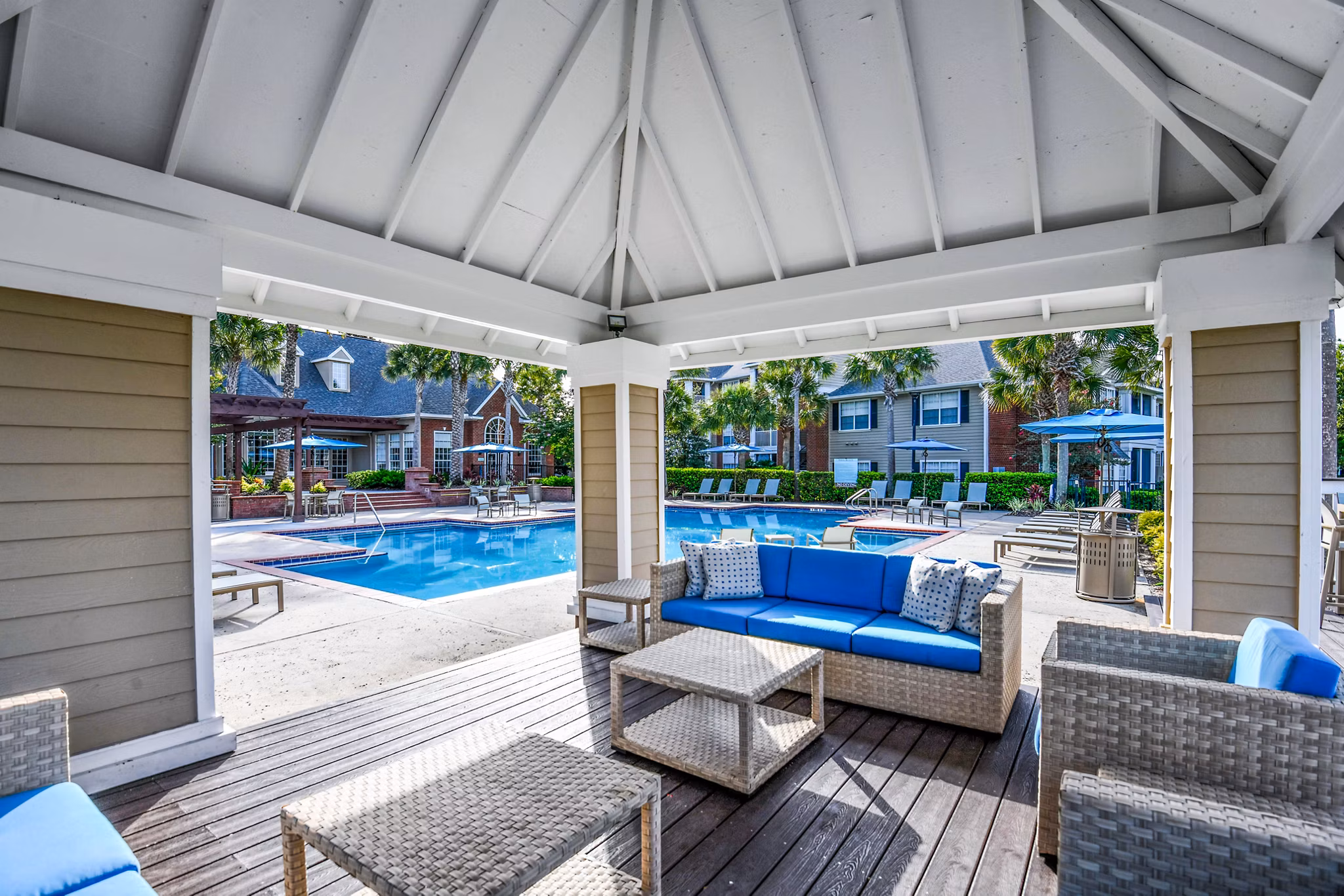 Sunny outdoor pool and patio area at 54 Magnolia Apartments offering a luxurious and relaxing environment
