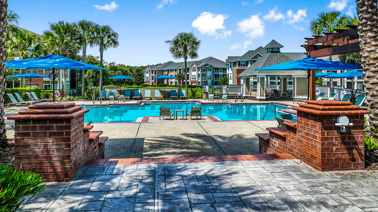 Inviting outdoor pool at 54 Magnolia Apartments with lush landscaping and seating areas for relaxation
