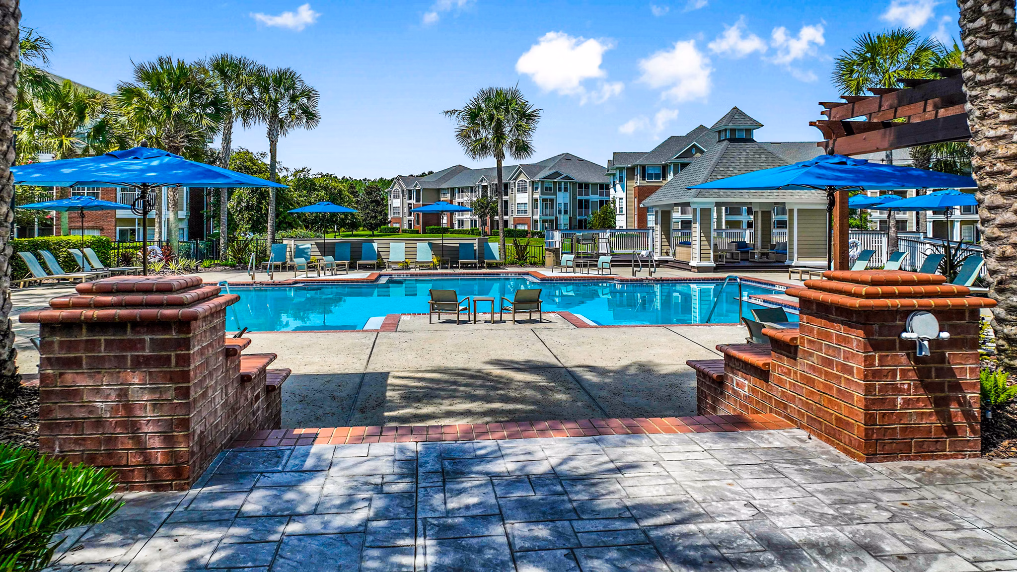 Inviting outdoor pool at 54 Magnolia Apartments with lush landscaping and seating areas for relaxation