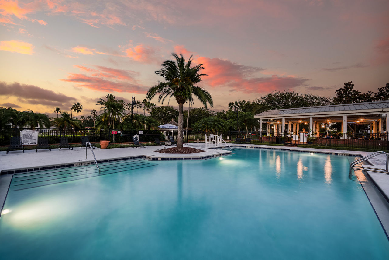 Luxurious outdoor pool with lounge chairs at Park Central Apartments - Manor Row, perfect for relaxation in serene surroundings
