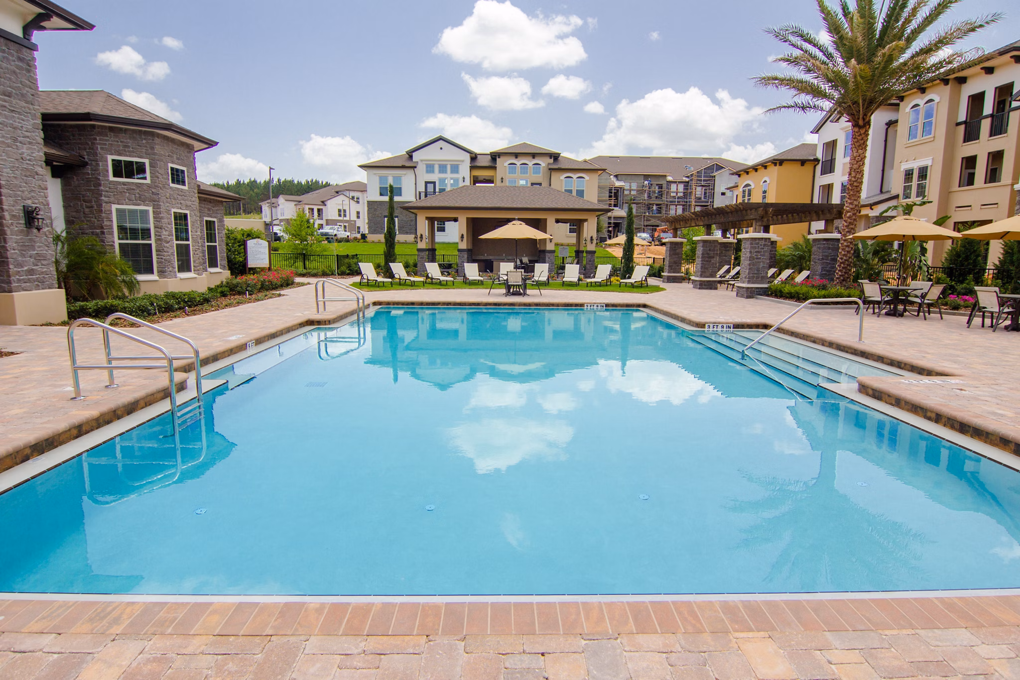 Sunlit outdoor pool at The Vineyards at Hammock Ridge Apartments offering a relaxing escape in luxury community living