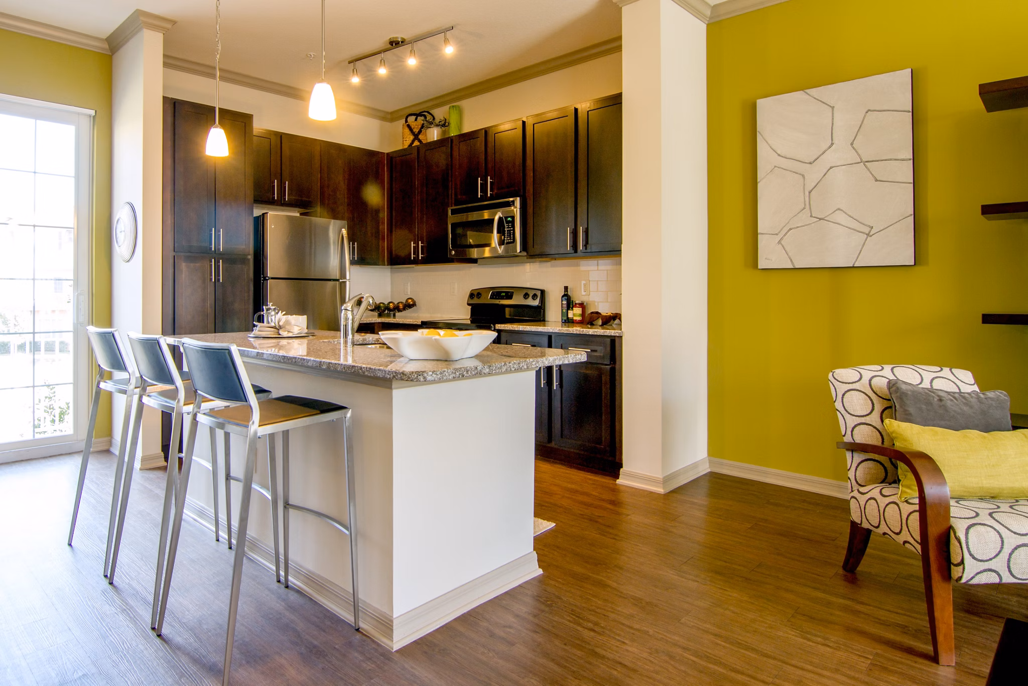Modern kitchen with stainless steel appliances and granite countertops in Midtown Delray Apartments, Greystar luxury community