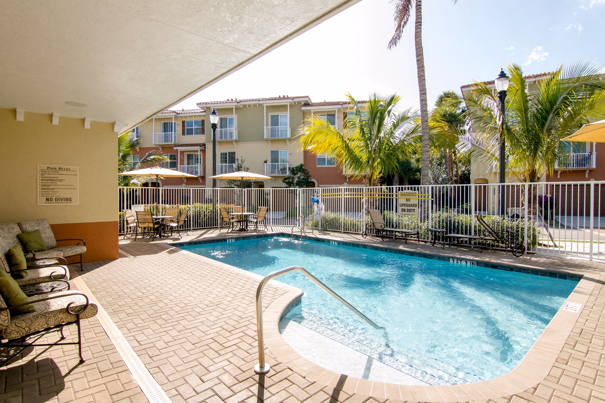 Luxurious poolside with sun loungers at Midtown Delray Apartments, a Greystar luxury apartment community