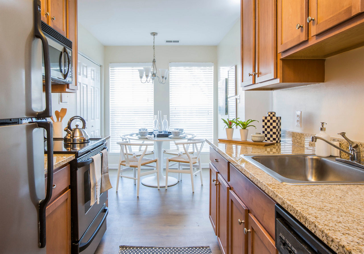 Modern kitchen with stainless steel appliances and granite countertops in Bayshore Landing Apartments