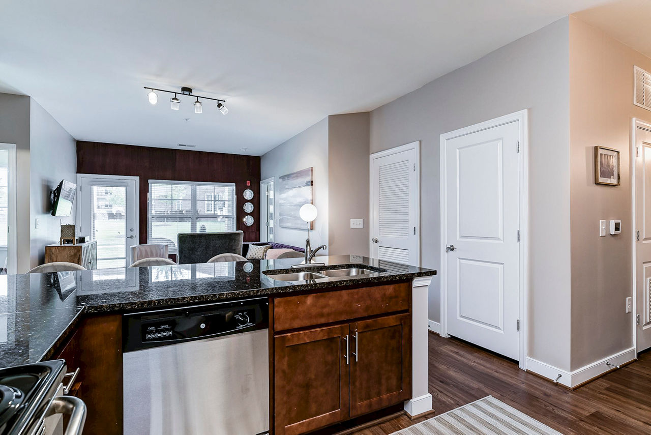 Modern kitchen with stainless steel appliances and granite countertops in Paragon at Columbia Overlook Apartments