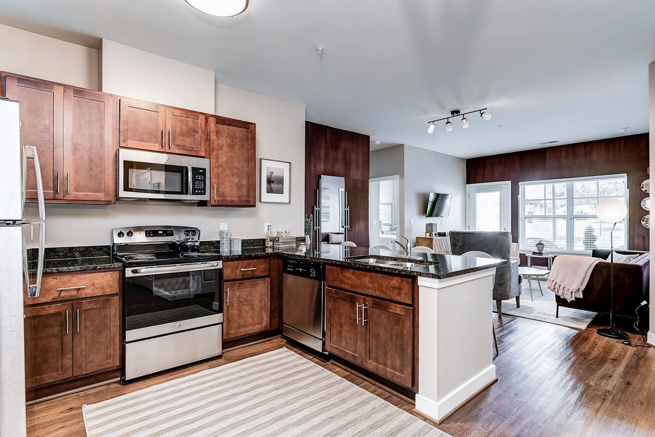 Modern kitchen with stainless steel appliances and marble countertops at Paragon at Columbia Overlook Apartments
