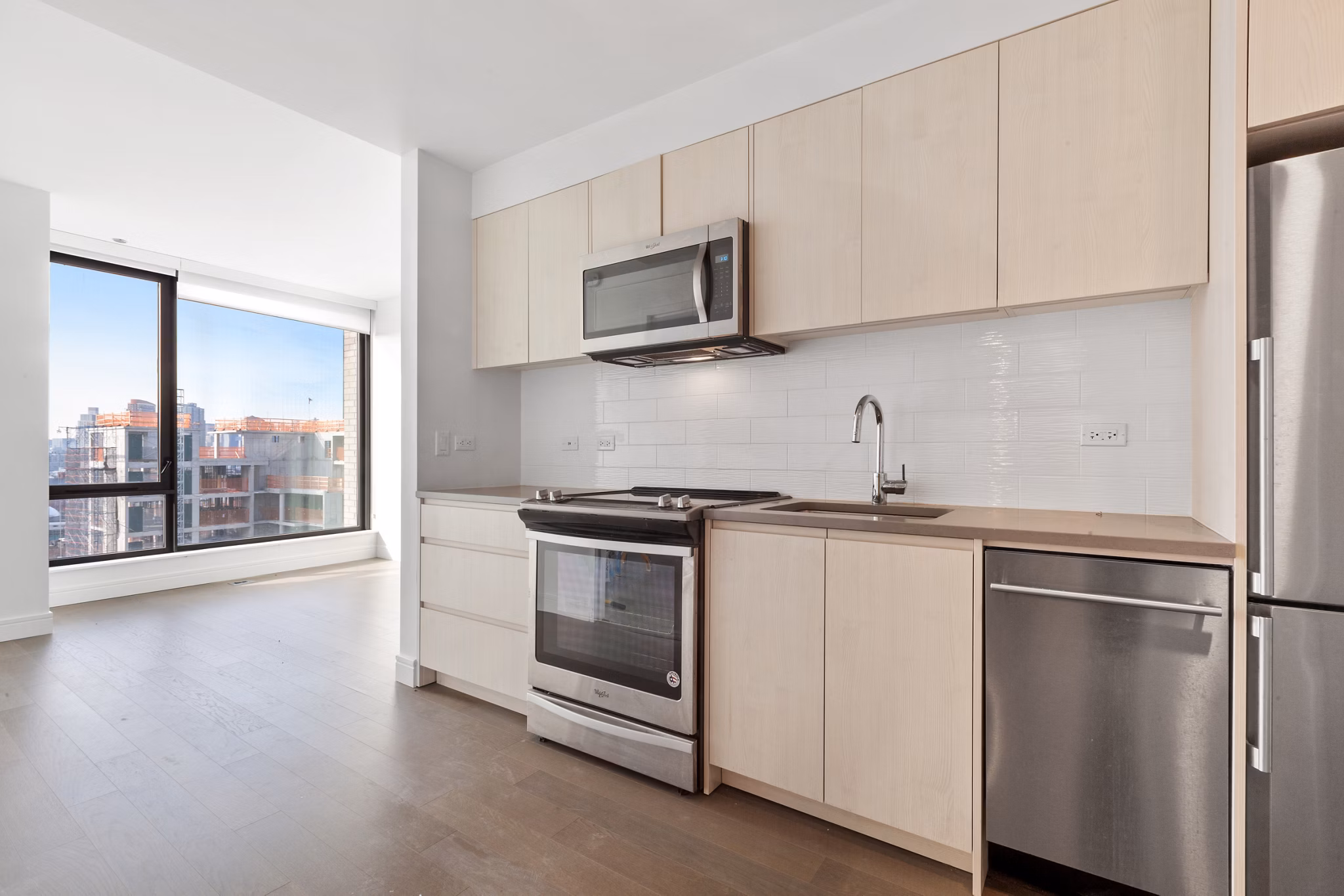 Modern kitchen with espresso cabinets and stainless steel appliances in Watermark LIC luxury apartments