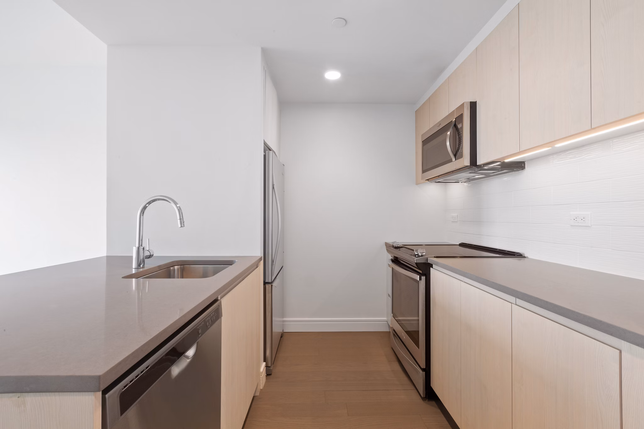 Modern kitchen with sleek cabinetry and stainless steel appliances at Watermark LIC apartments