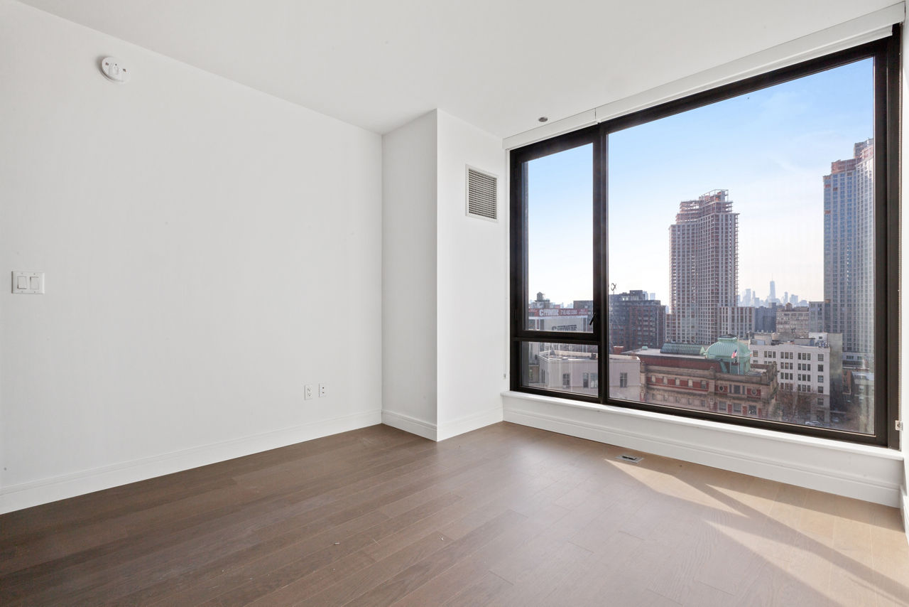 Living room with contemporary decor and large windows at Watermark LIC luxury apartments