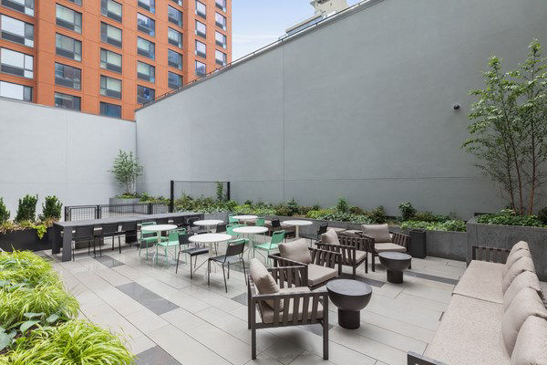 Watermark LIC: Modern patio space with sleek furnishings and skyline views