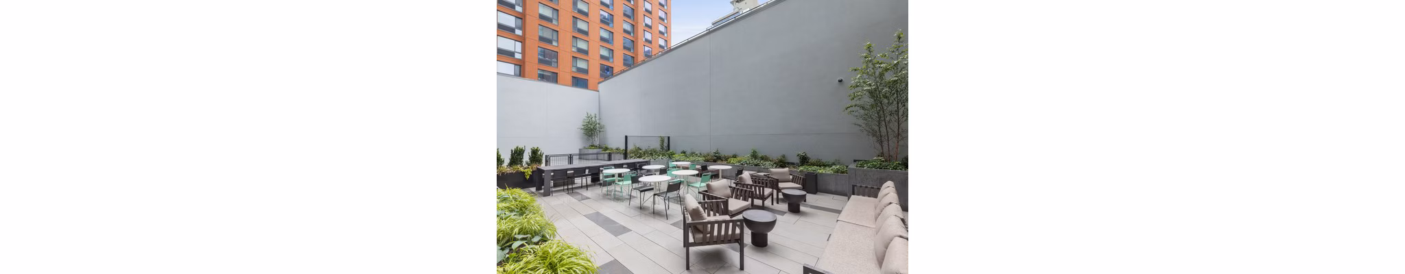 Watermark LIC: Modern patio space with sleek furnishings and skyline views