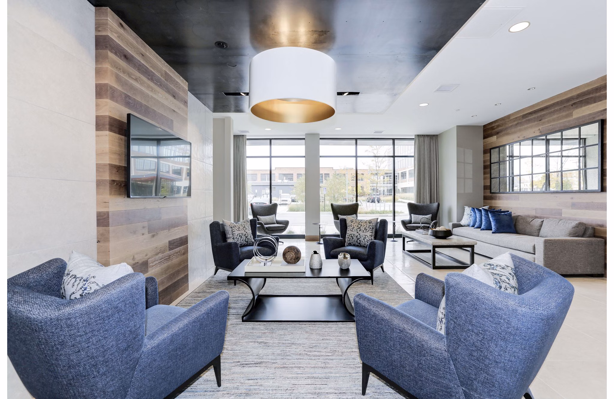 Modern clubhouse with lounge seating and large-screen TVs at Porter Street Apartments for communal relaxation and entertainment