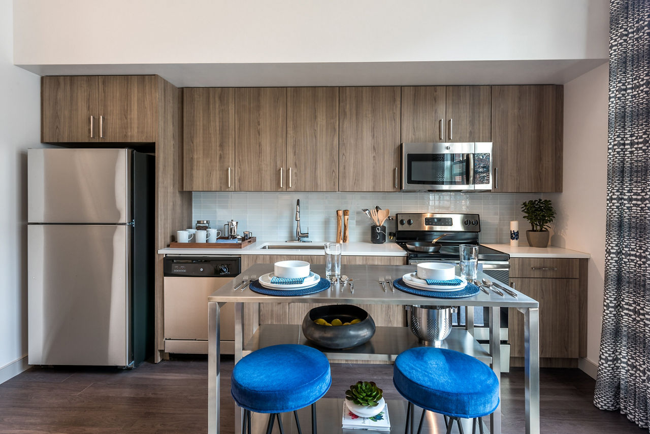 Modern kitchen featuring stainless steel appliances and granite countertops in Greystar luxury apartment