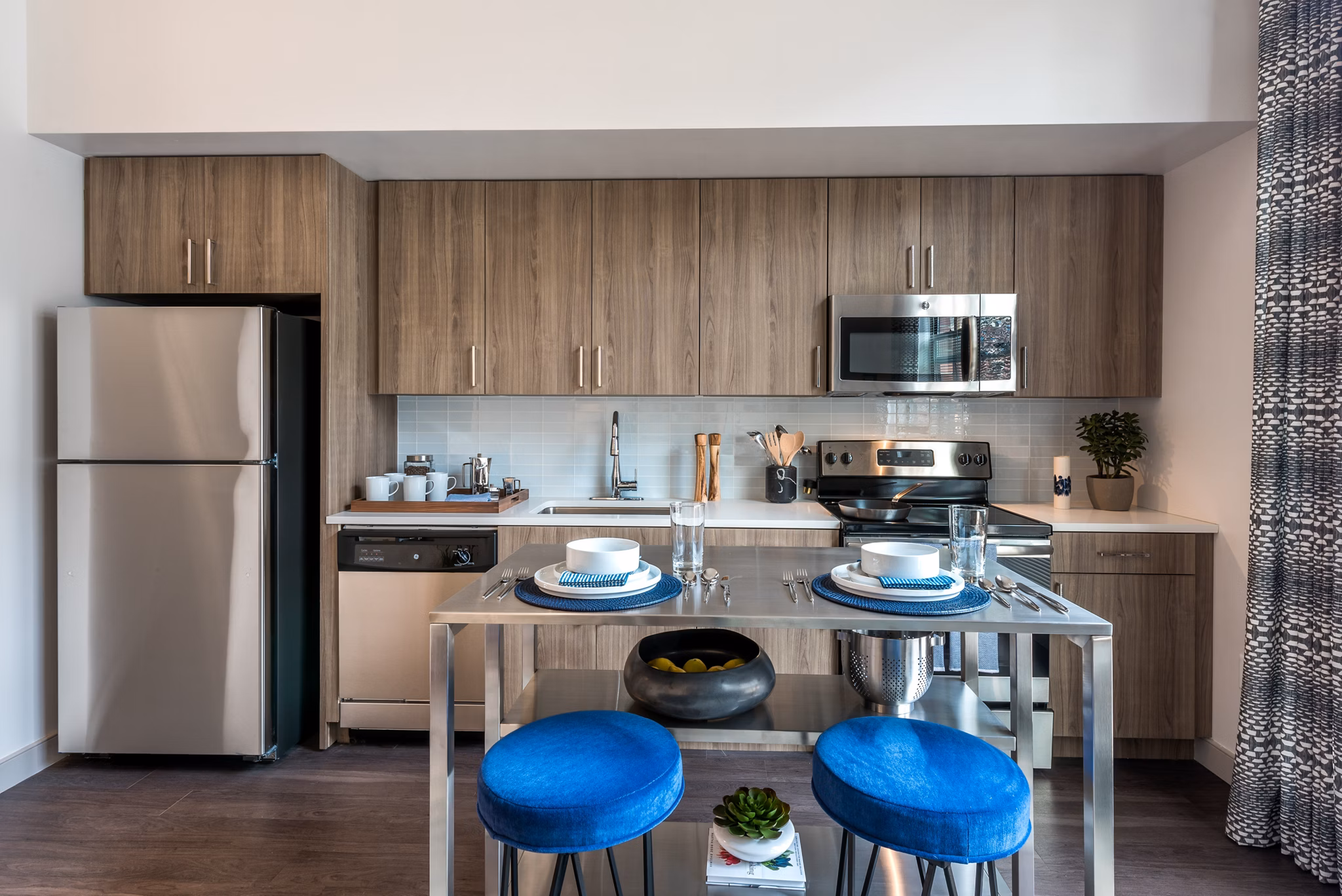Modern kitchen featuring stainless steel appliances and granite countertops in Greystar luxury apartment