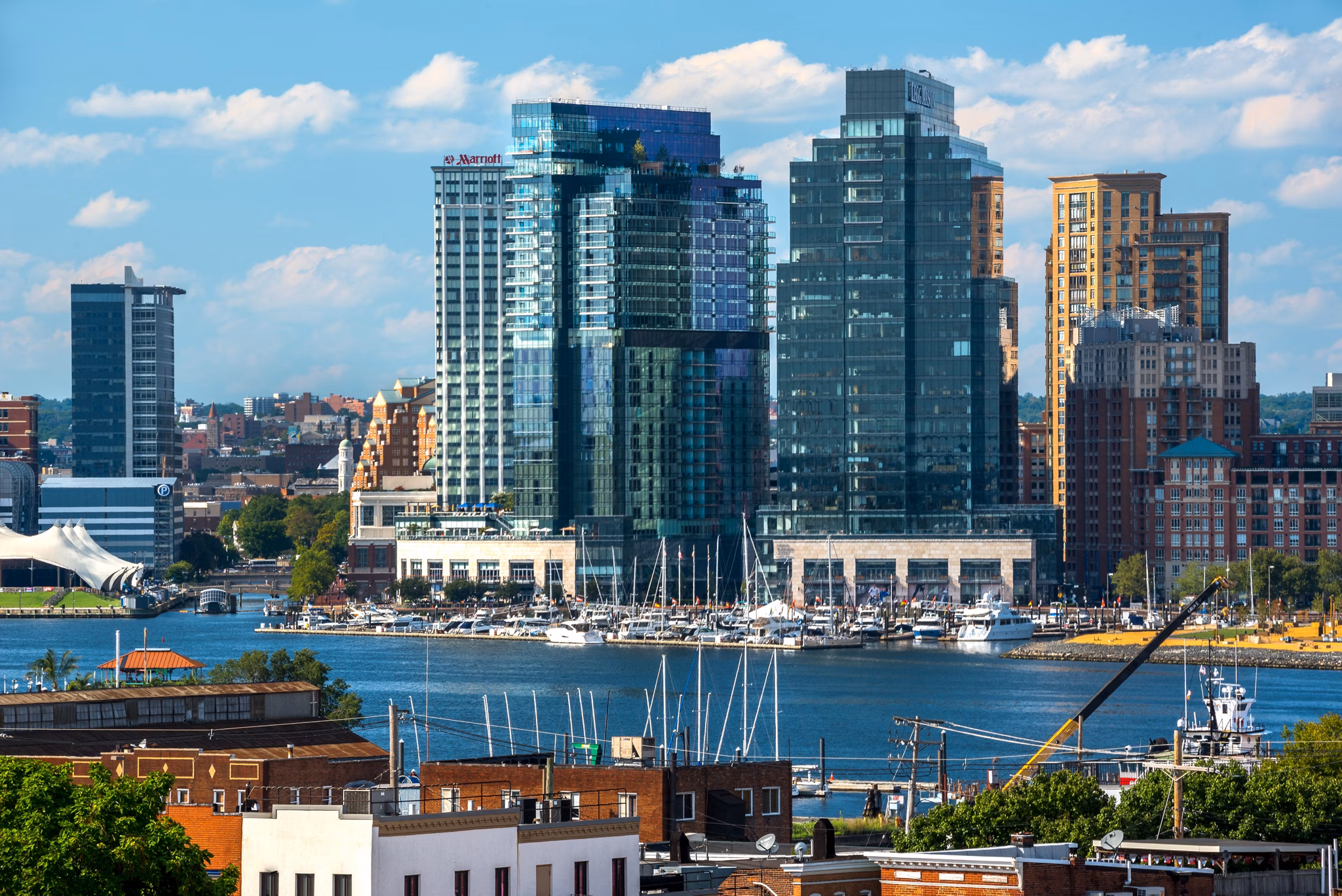 Cityscape featuring tall buildings and a marina with boats in luxury apartment neighborhood