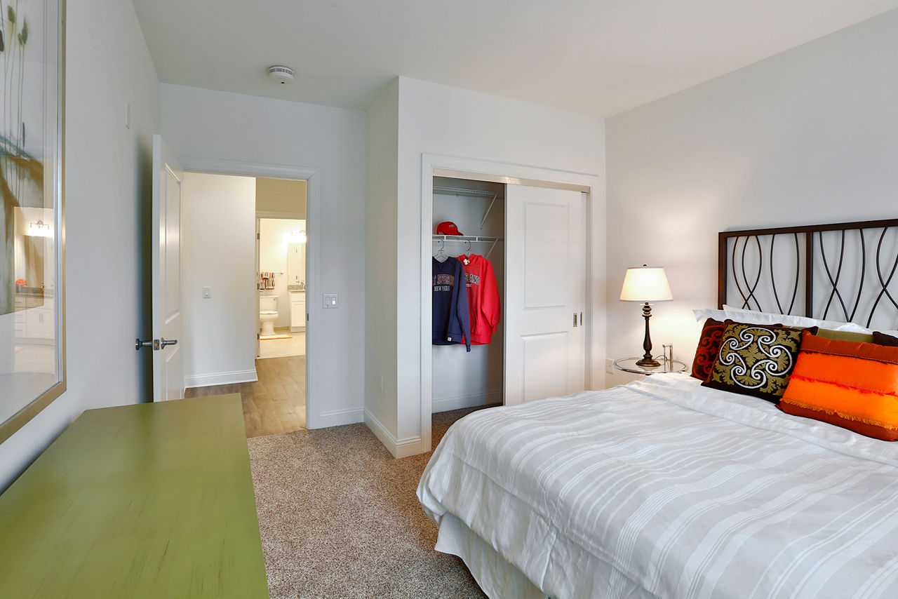 Modern bedroom with waterfront views at The Shipyard at Port Jefferson Harbor Apartments