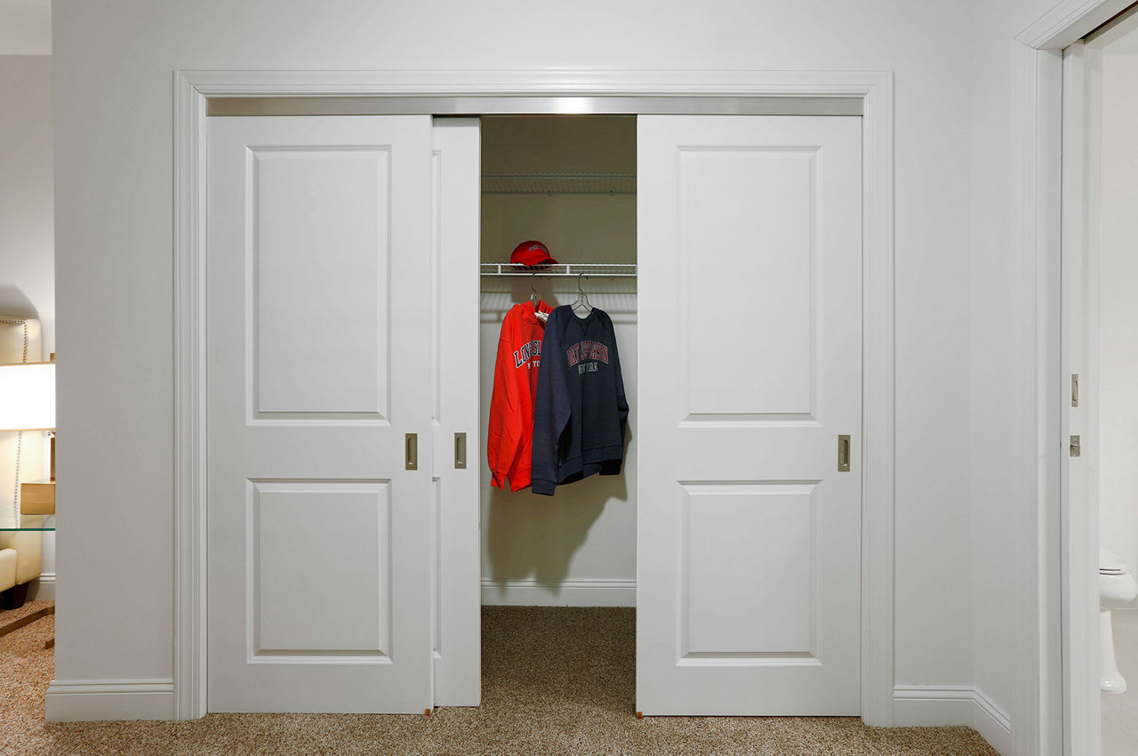 Walk-in bedroom closet with built-in shelves at The Shipyard at Port Jefferson Harbor Apartments