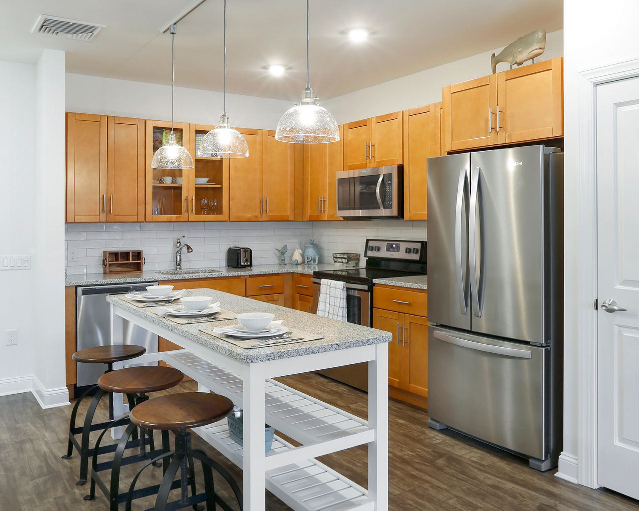 Modern kitchen with stainless steel appliances and granite countertops at The Shipyard at Port Jefferson Harbor Apartments