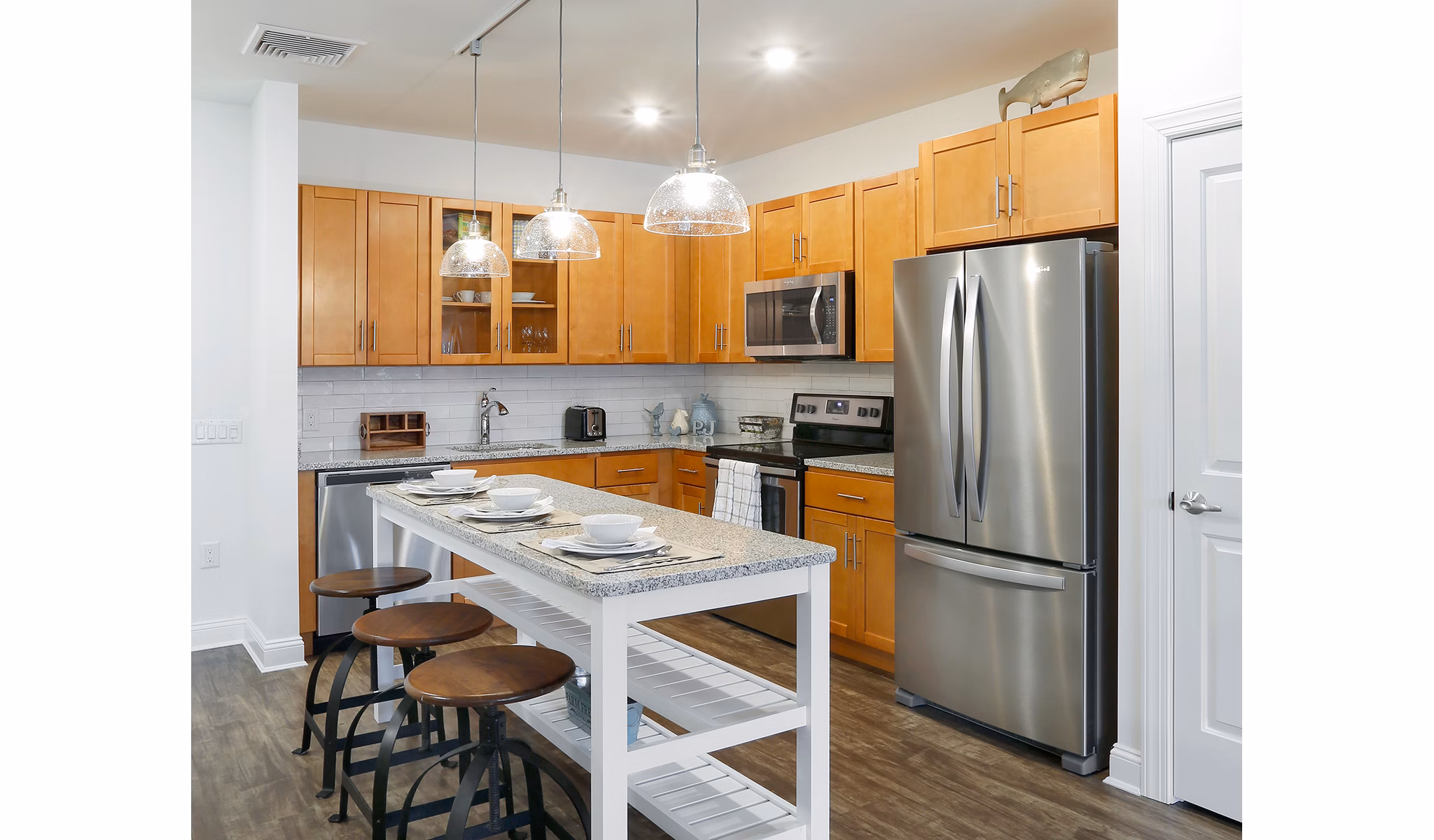 Modern kitchen with stainless steel appliances and granite countertops at The Shipyard at Port Jefferson Harbor Apartments