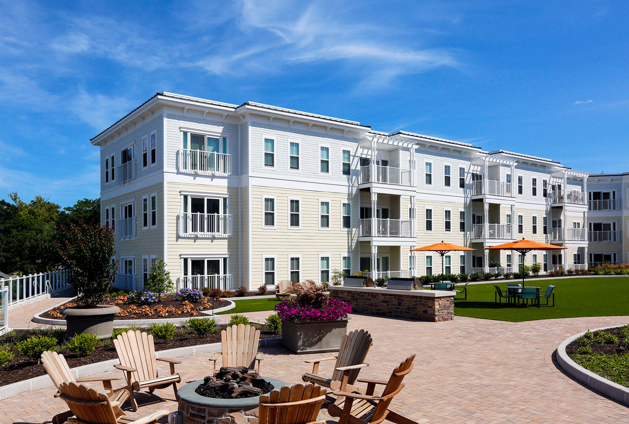 Cozy fire pit area at The Shipyard at Port Jefferson Harbor Apartments, ideal for social gatherings and relaxation
