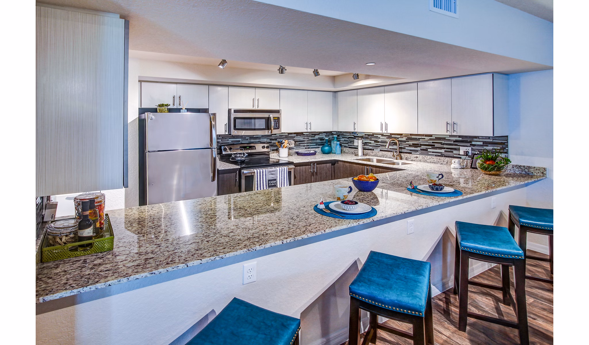 Modern kitchen with stainless steel appliances at The Quaye at Palm Beach Gardens Apartments