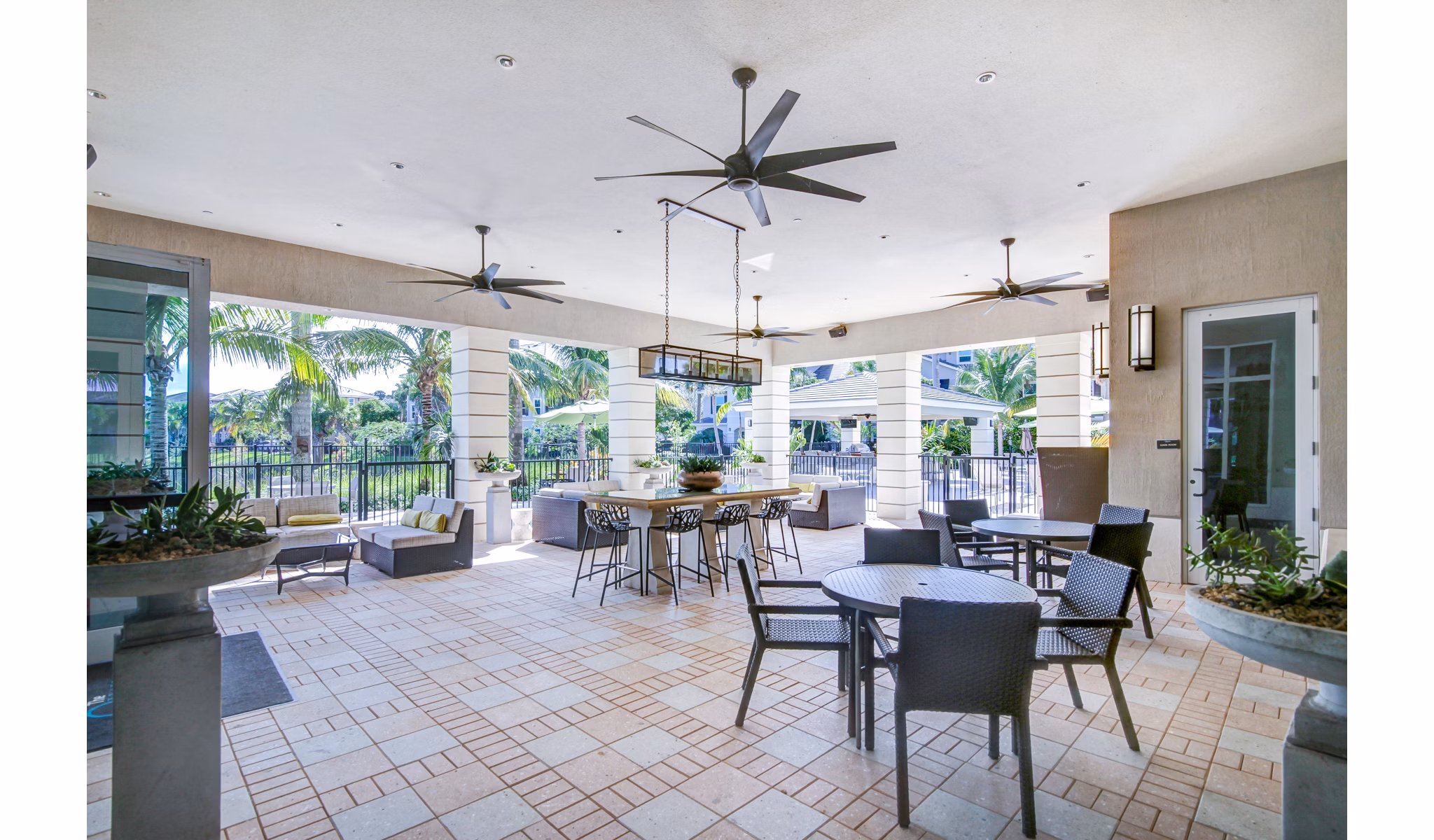Grill area with outdoor seating at The Quaye at Palm Beach Gardens Apartments, ideal for gatherings and leisure activities
